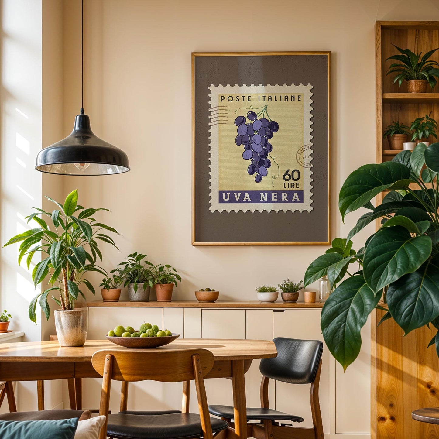 a cozy dining area with a wooden table, chairs, and a potted plant. A framed stamp with a grape bunch and the text "POSTE ITALIERE 60 LIRE UVA NERÁ" hangs on the wall above the table.