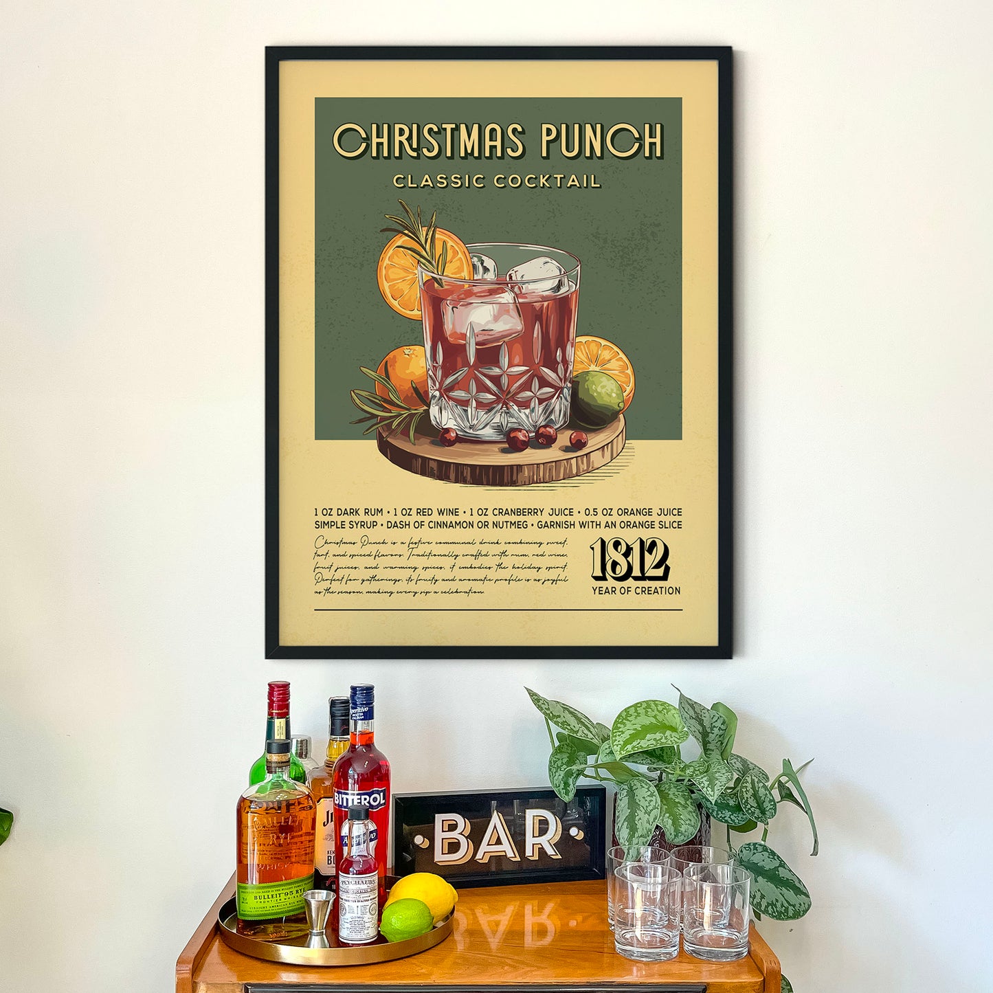 a framed poster of a Christmas Punch cocktail recipe hanging on a wall above a wooden bar counter with various liquor bottles and glasses.
