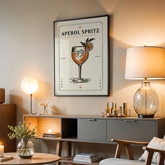a living room with a framed poster of an Aperol Spritz cocktail hanging on the wall. The poster displays an illustration of a glass filled with the Aperol Spritz drink, accompanied by a lemon slice and a small orange. The room is furnished with a wooden cabinet, a lamp, and a chair, creating a cozy and inviting atmosphere.