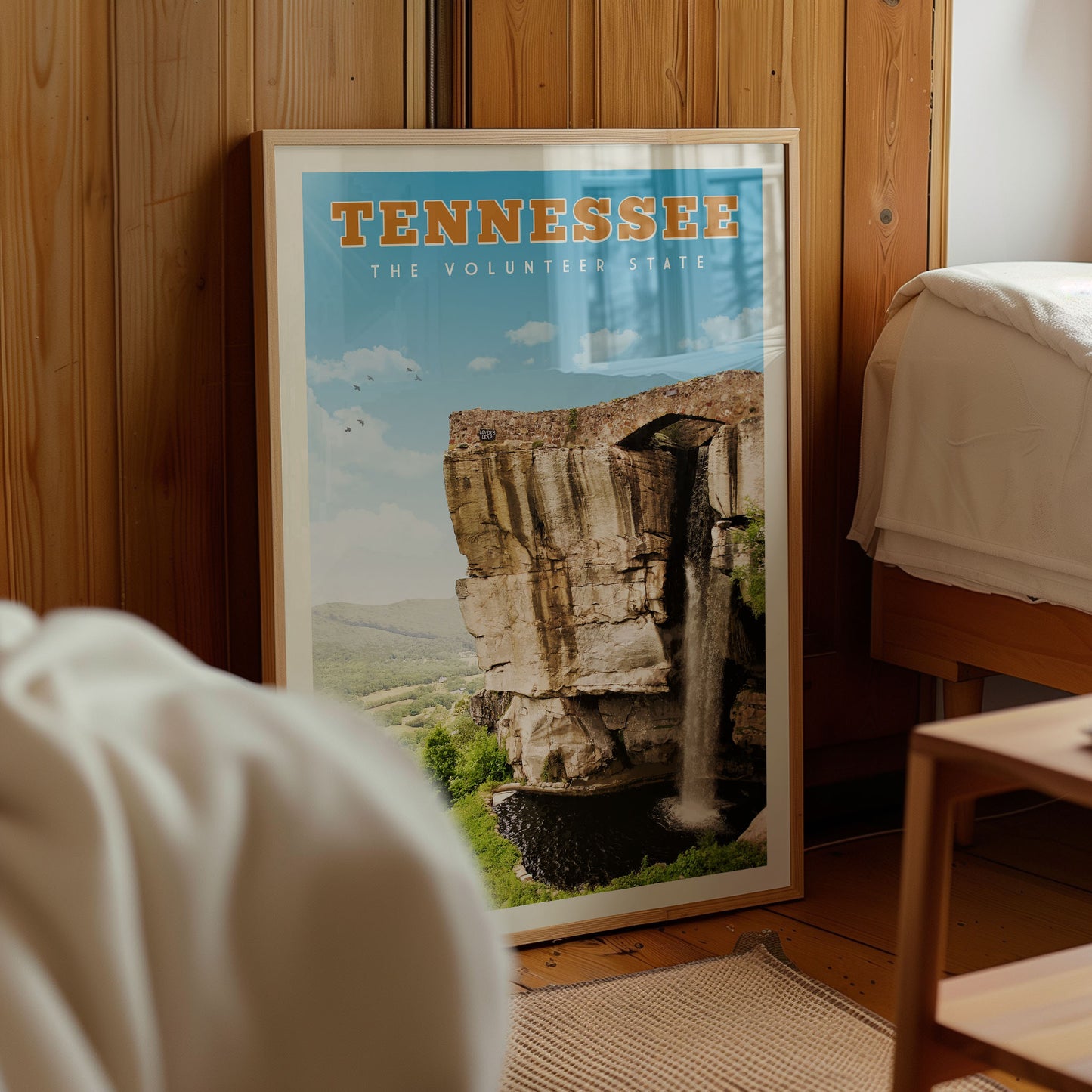 A framed poster of a waterfall in Tennessee, with the text "TENNESSEE THE VOLUNTEER STATE" printed on it.
