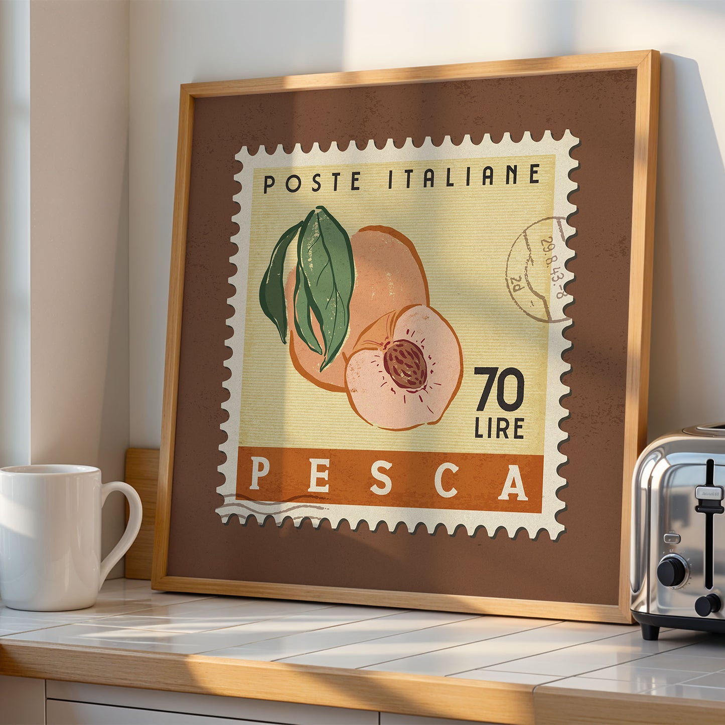 a framed stamp-like artwork depicting a peach, with the text "POSTE ITALIANE 70 LIRE PESCA" printed on it. The artwork is displayed on a wooden shelf, with a white mug and a toaster visible in the background.