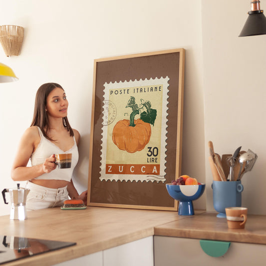 a woman standing in a kitchen next to a framed poster