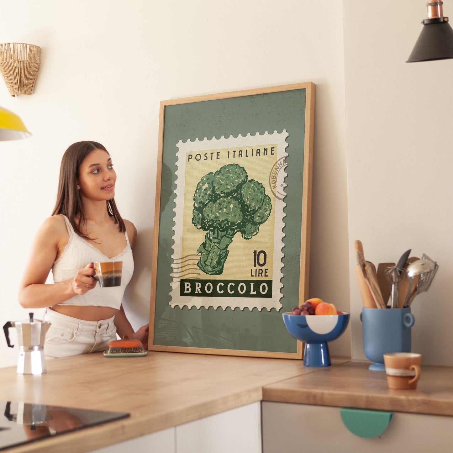 a woman standing in a kitchen next to a poster