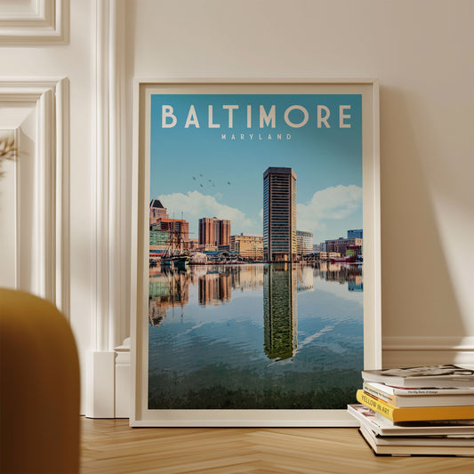 A framed poster of the Baltimore skyline, featuring the city's iconic skyline and water reflection, is displayed on a wall.