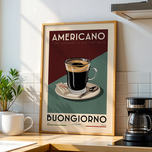 a framed poster of an Americano coffee cup on a saucer, with the text "AMERICANO 1 SHOT EXPRESSION 2 PARTS HOT WATER" and "BUONGIORNO" below it. The poster is displayed on a kitchen counter, with a coffee maker and a potted plant visible in the background.