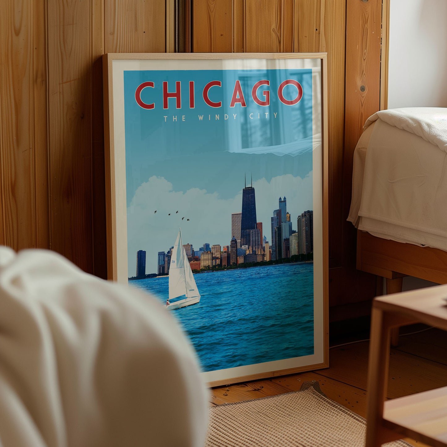 A framed poster of Chicago, featuring a sailboat on the water with the city skyline in the background.