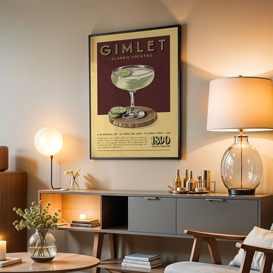 a framed poster of a cocktail on a wall, with a lamp, a vase of flowers, and a bookshelf below it.