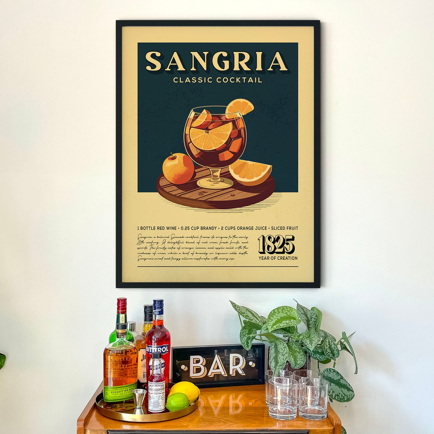 a framed poster of a classic cocktail called "Sangria" hanging on a wall above a wooden bar counter with various liquor bottles and glasses.