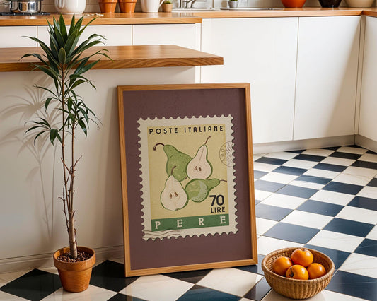 a framed stamp-like artwork depicting pears, placed on a checkered floor next to a potted plant and a basket of oranges.