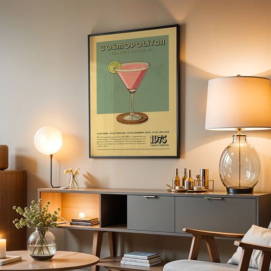 a living room with a framed poster of a cocktail on the wall, a lamp, a vase with flowers, and a bookshelf.