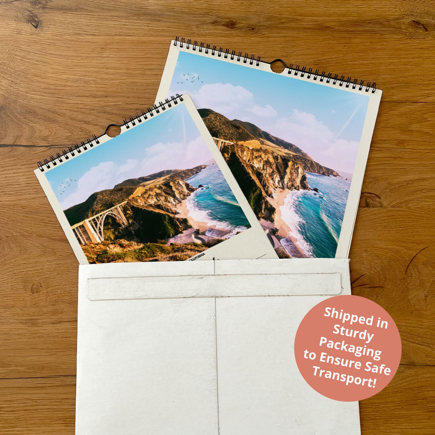 two printed photographs of a scenic coastal landscape, including a bridge and mountains, placed inside a white envelope on a wooden surface.