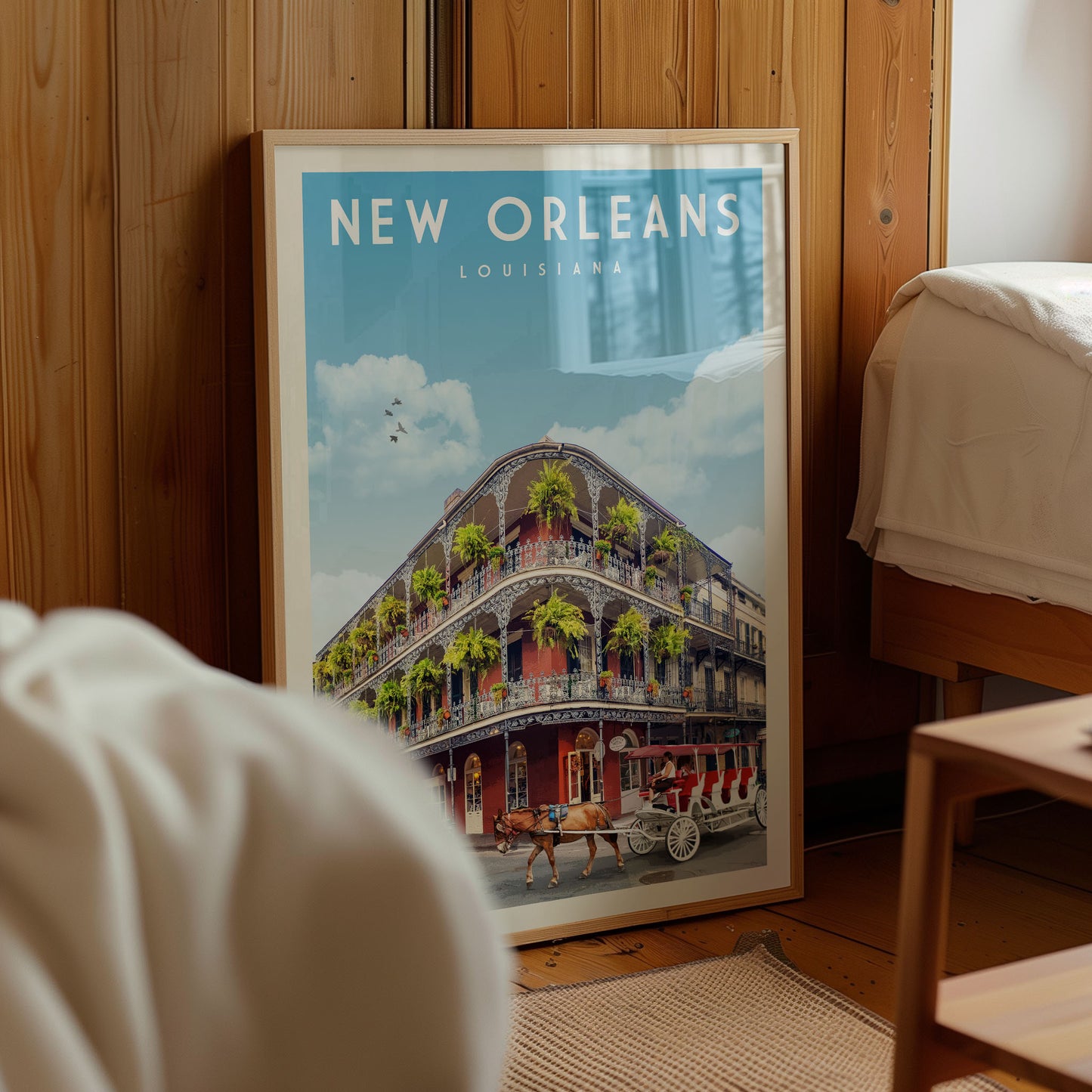 A framed poster of the New Orleans, Louisiana, street scene is displayed in a room with a wooden wall and a bed visible in the background.