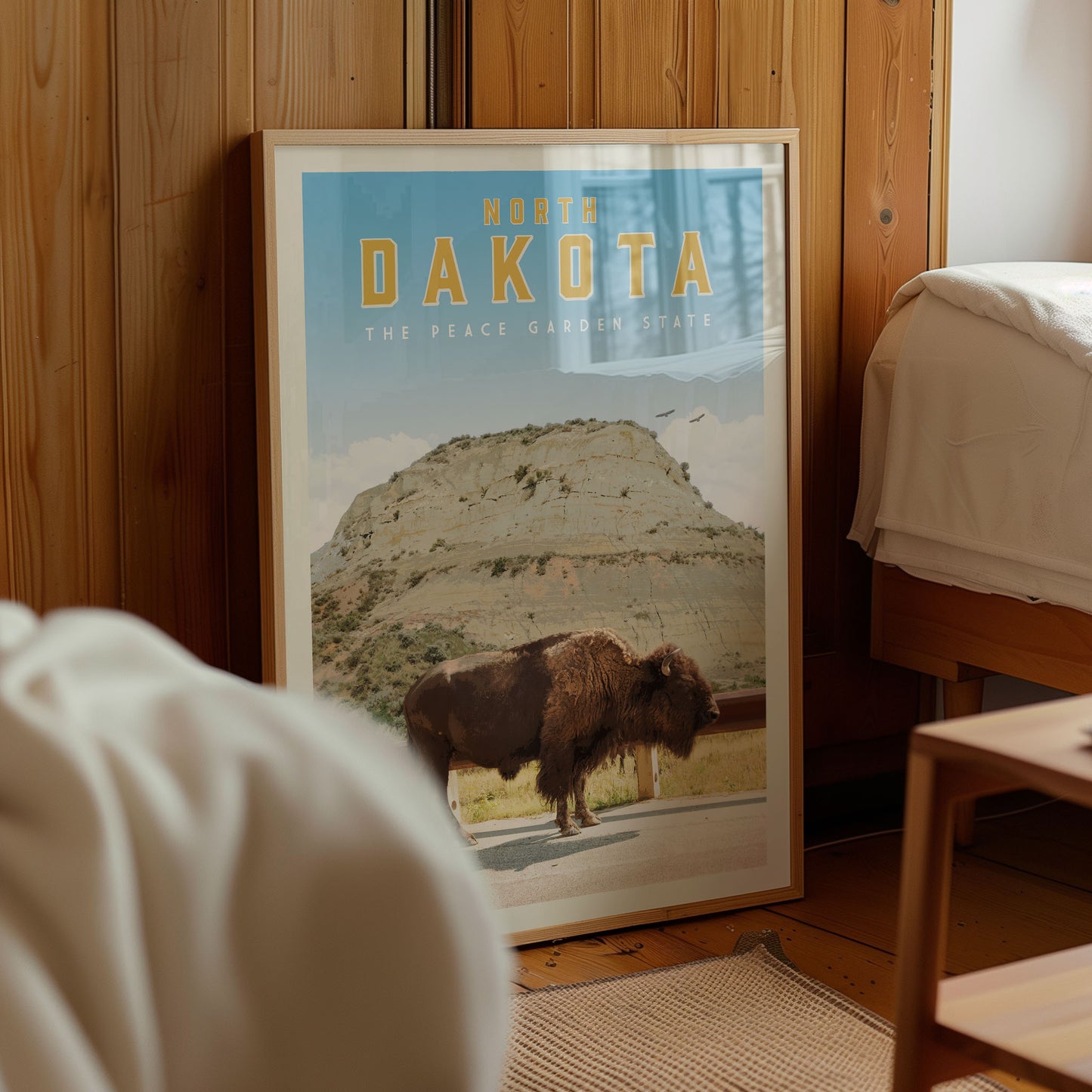 a framed poster of a bison in a field, with the text "NORTH DAKOTA" and "THE PEACE GARDEN STATE" printed on it.