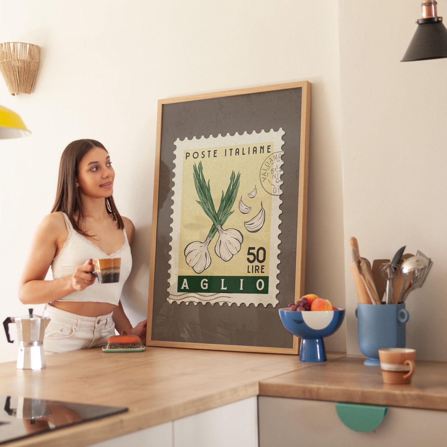 a woman standing in a kitchen next to a framed poster
