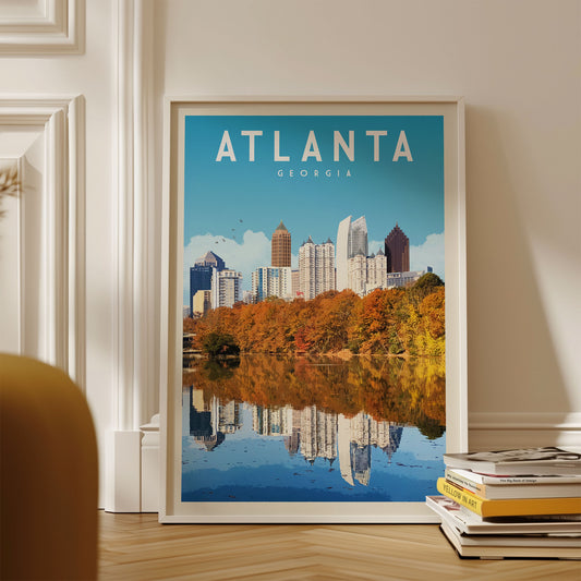 A framed poster of the Atlanta skyline, featuring the city's iconic buildings reflected in a body of water, is displayed on a wall.
