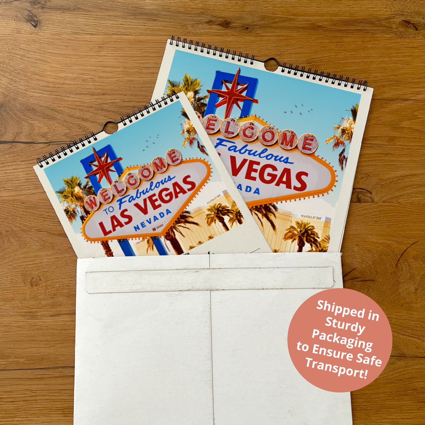 A calendar featuring the Las Vegas sign is placed inside a white envelope, with a shipping label indicating it was shipped in sturdily packaged to ensure safe transport.