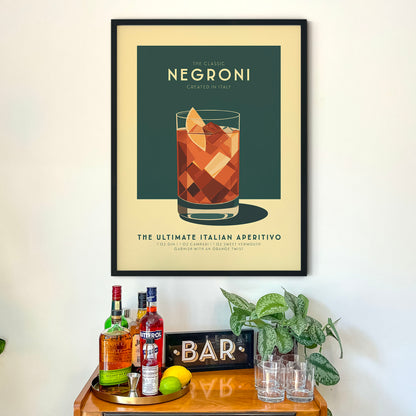 a framed poster of a Negroni cocktail on a wall above a wooden bar counter with various liquor bottles and glasses.