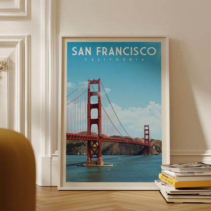 A framed poster of the Golden Gate Bridge in San Francisco, California, displayed on a wall.