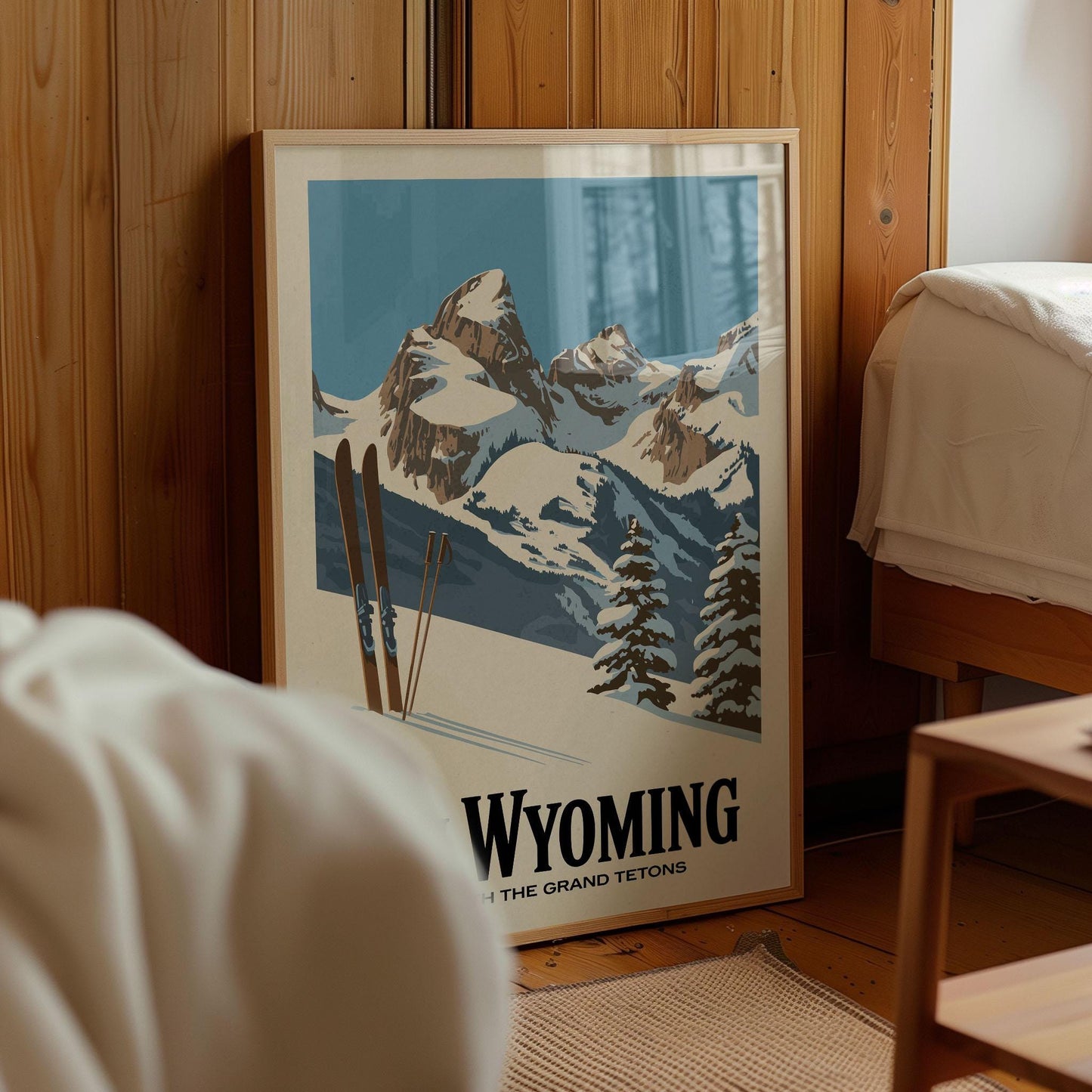 A framed poster of a snowy mountain landscape with skis, depicting the Grand Teton range in Wyoming.
