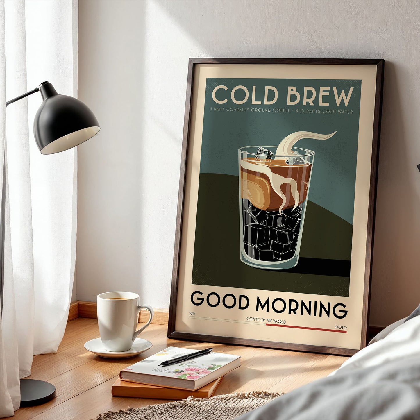 a framed poster of a glass of cold brew coffee with ice cubes, placed on a wooden table next to a lamp and a book.