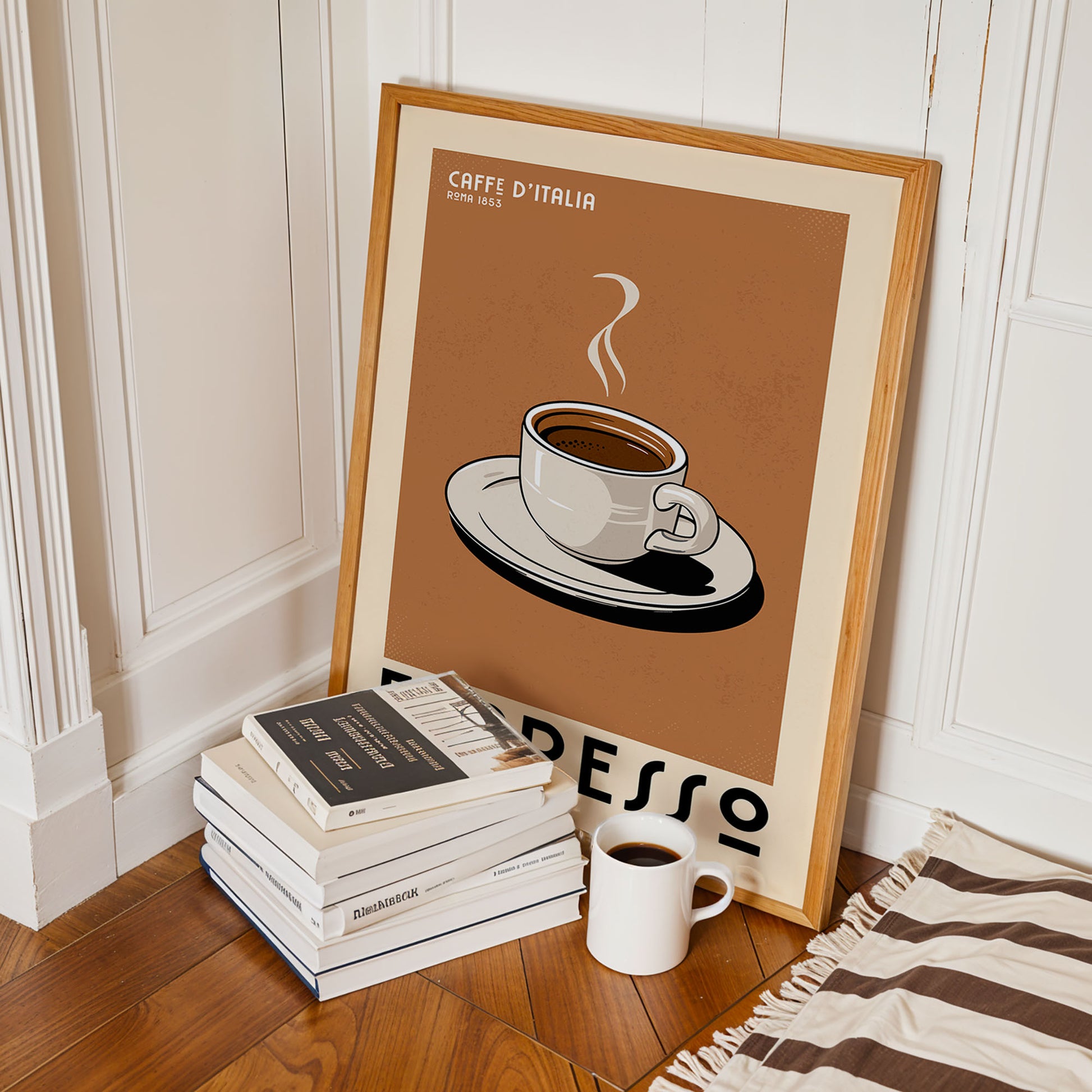 a framed poster of a cup of espresso, a stack of books, and a white mug on a wooden floor.