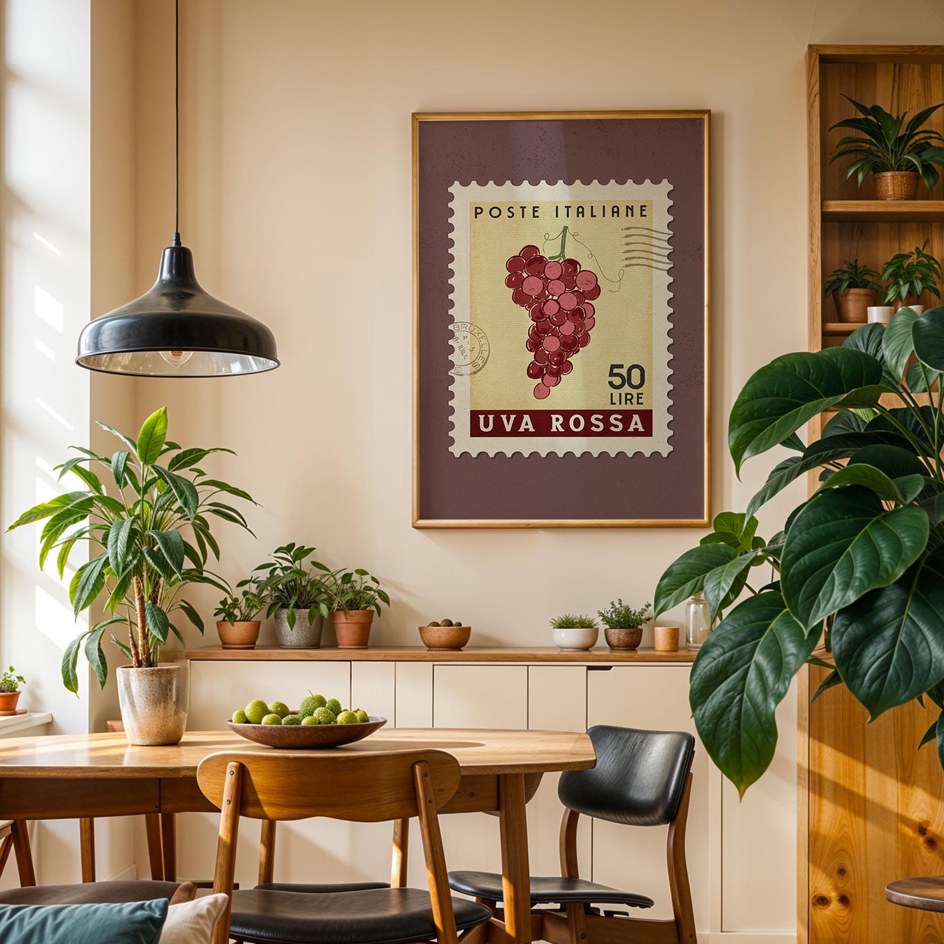 a cozy dining area with a wooden table, chairs, and potted plants. A framed stamp with a grape vine and the text &quot;POSTE ITALIERE 50 LIME UVA ROSSA&quot; hangs on the wall above the table.