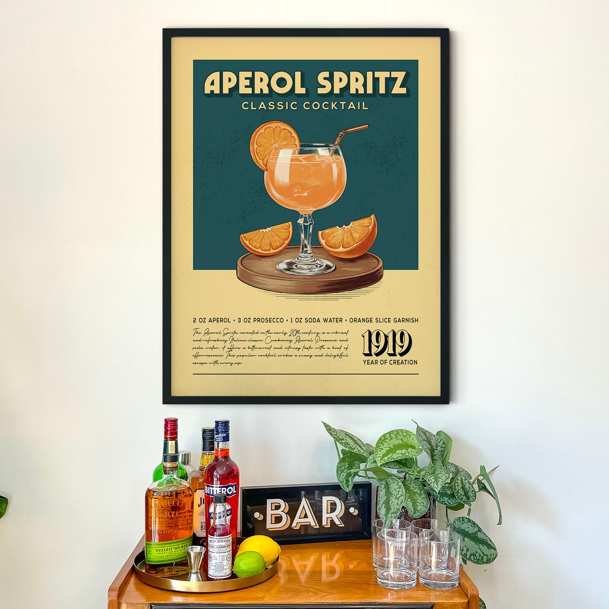 a framed poster of an Aperol Spritz cocktail recipe, along with a wooden bar display and various liquor bottles.