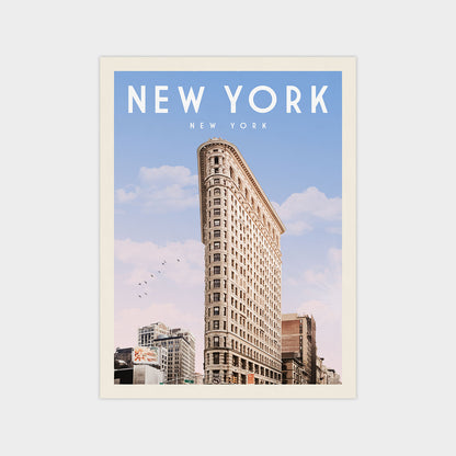 A tall, ornate building with a distinctive rounded corner, set against a clear blue sky with a few birds flying in the distance.