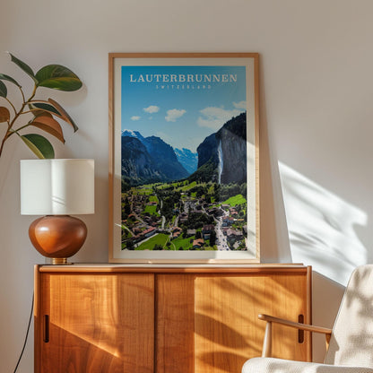 a framed poster of a scenic mountain landscape in Switzerland, with a wooden cabinet and a lamp in the foreground.