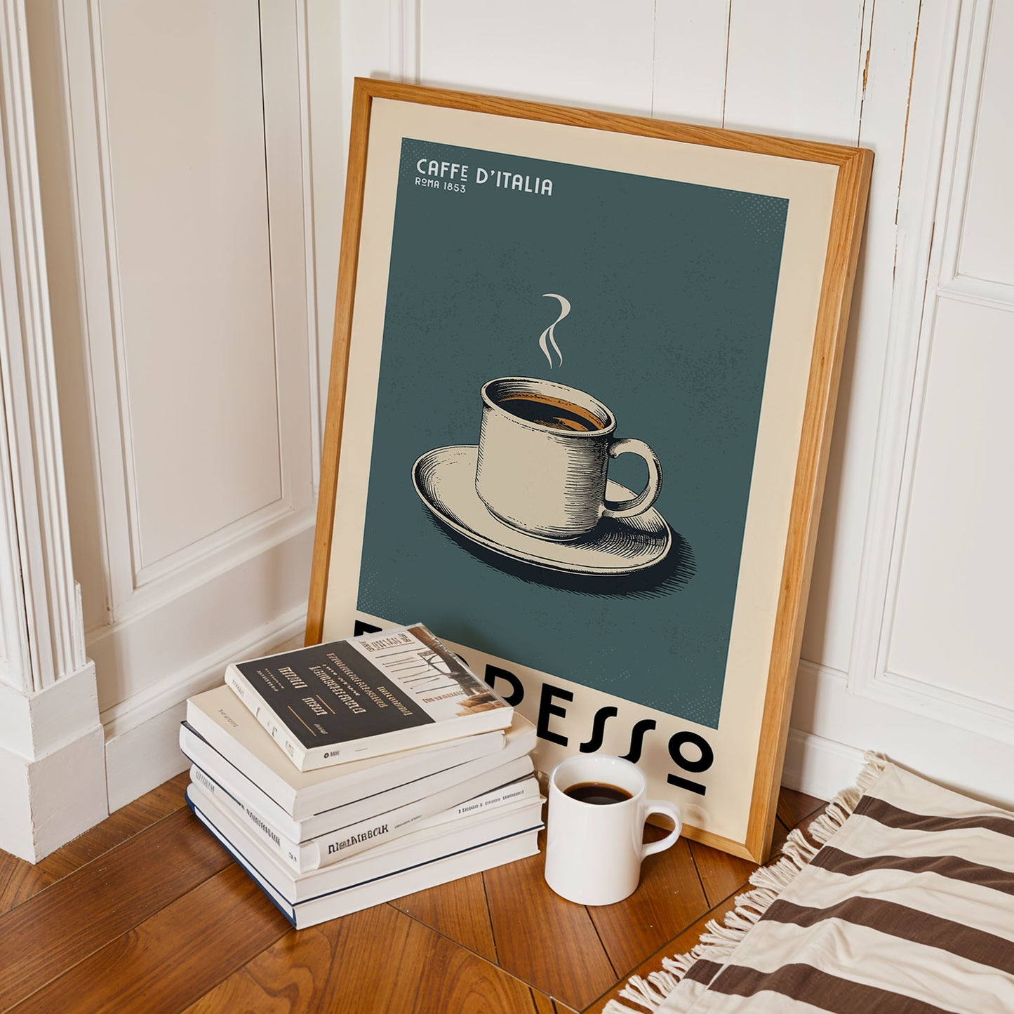 a framed poster of a cup of espresso, a stack of books, and a white mug on a wooden floor.