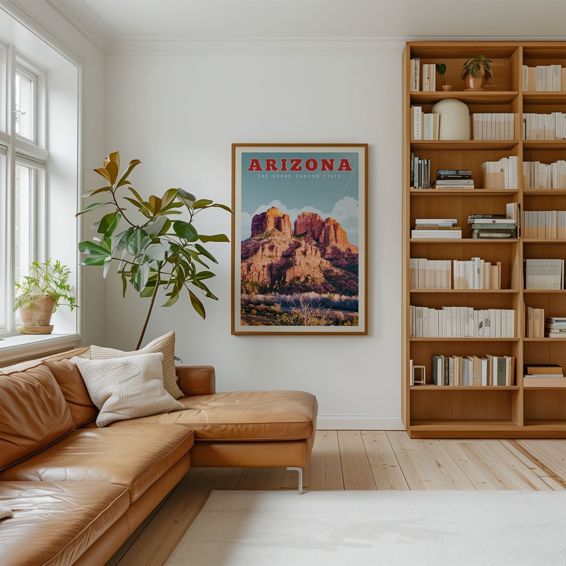 a cozy living room with a large framed poster of the Grand Canyon hanging on the wall, a comfortable leather couch, and a bookshelf filled with books.