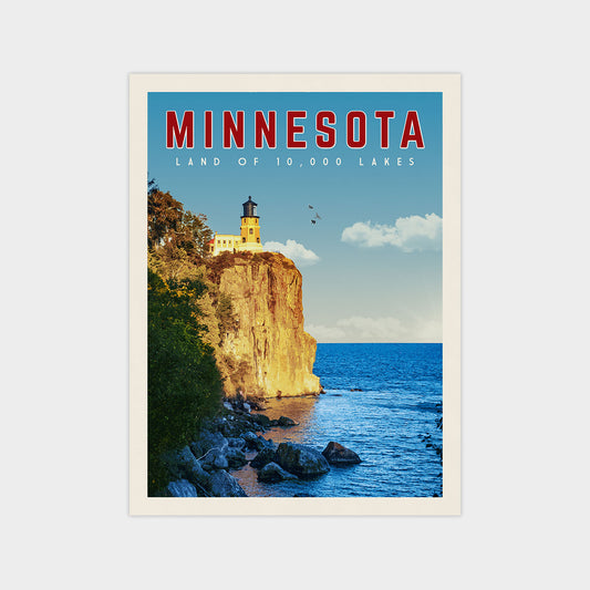 A framed poster depicting a scenic view of a lighthouse overlooking a lake in Minnesota, with a rocky cliff and a clear blue sky in the background.