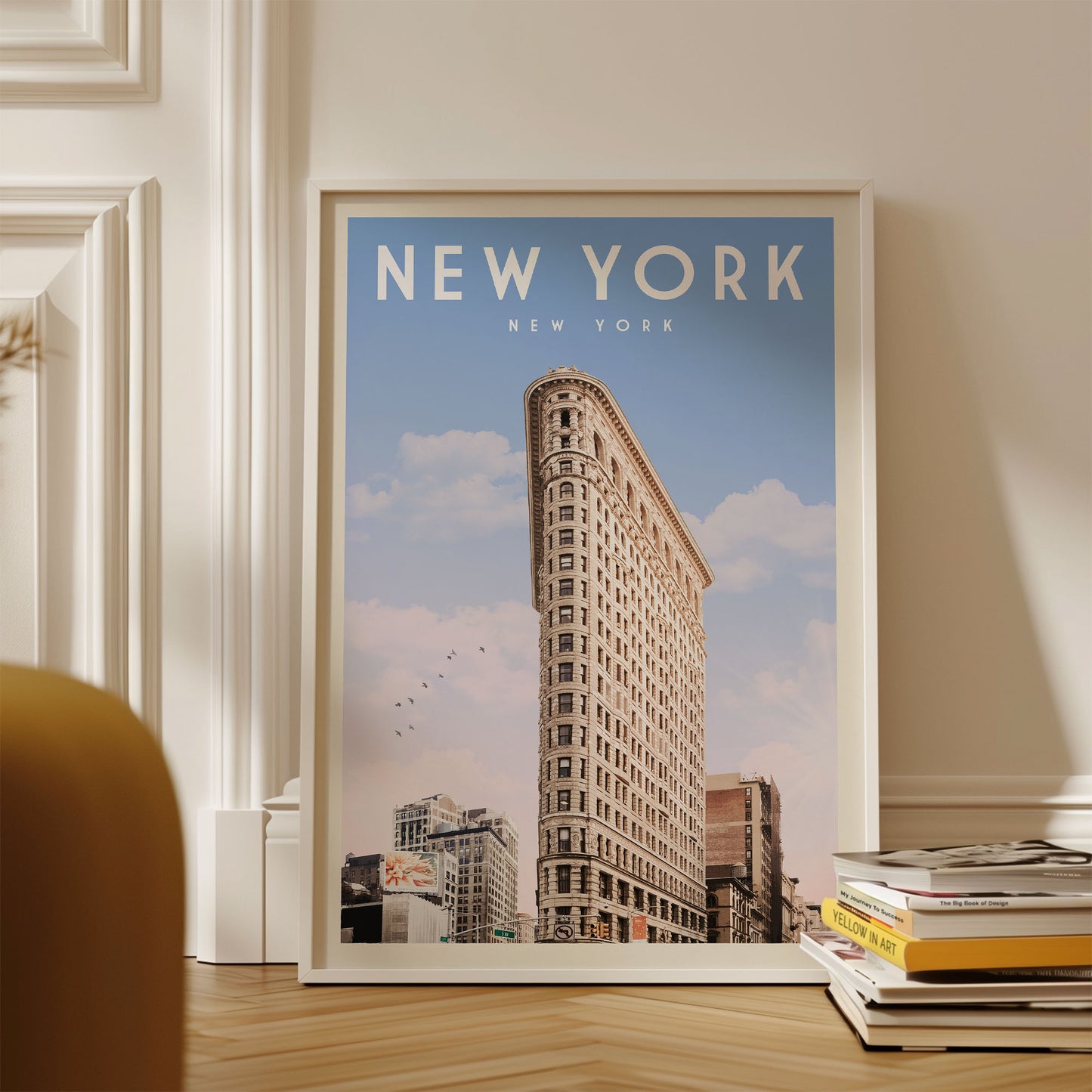 A framed poster of the Flatiron Building, a famous New York skyscraper, is displayed on a wall.