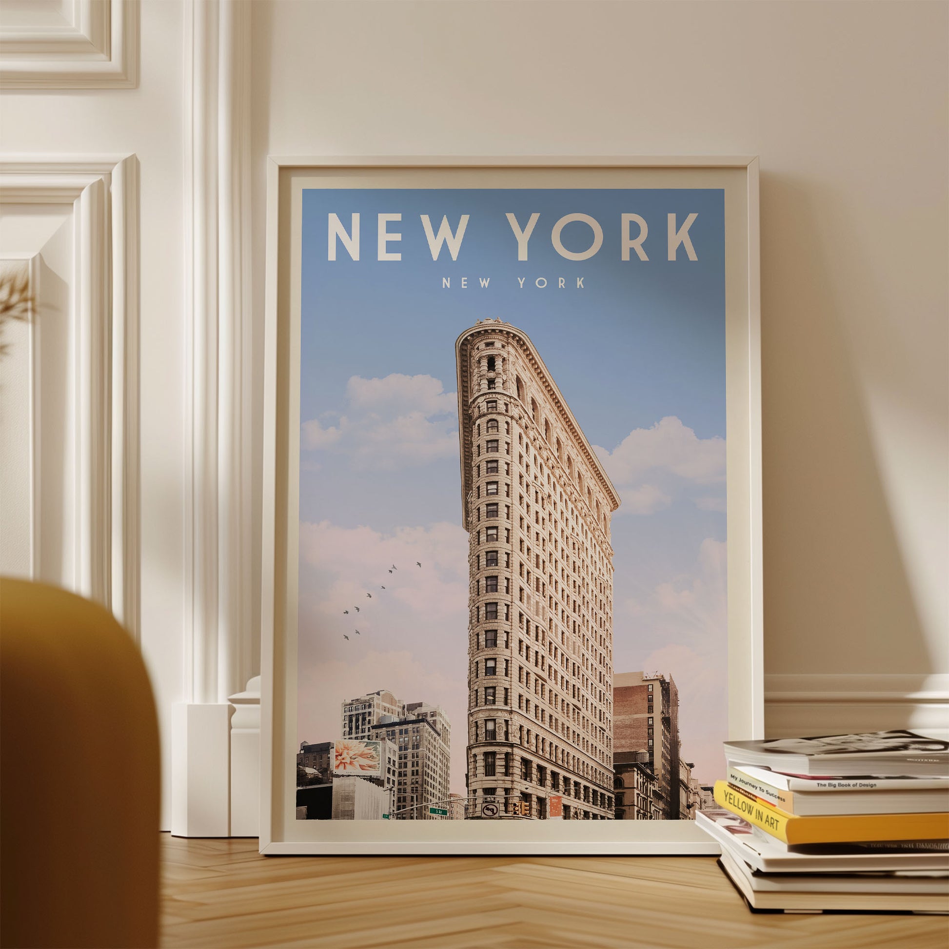 A framed poster of the Flatiron Building, a famous New York skyscraper, is displayed on a wall.