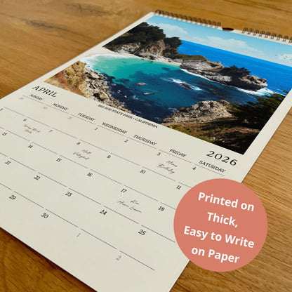 A wall calendar with a scenic coastal landscape photo on the cover, printed on paper.