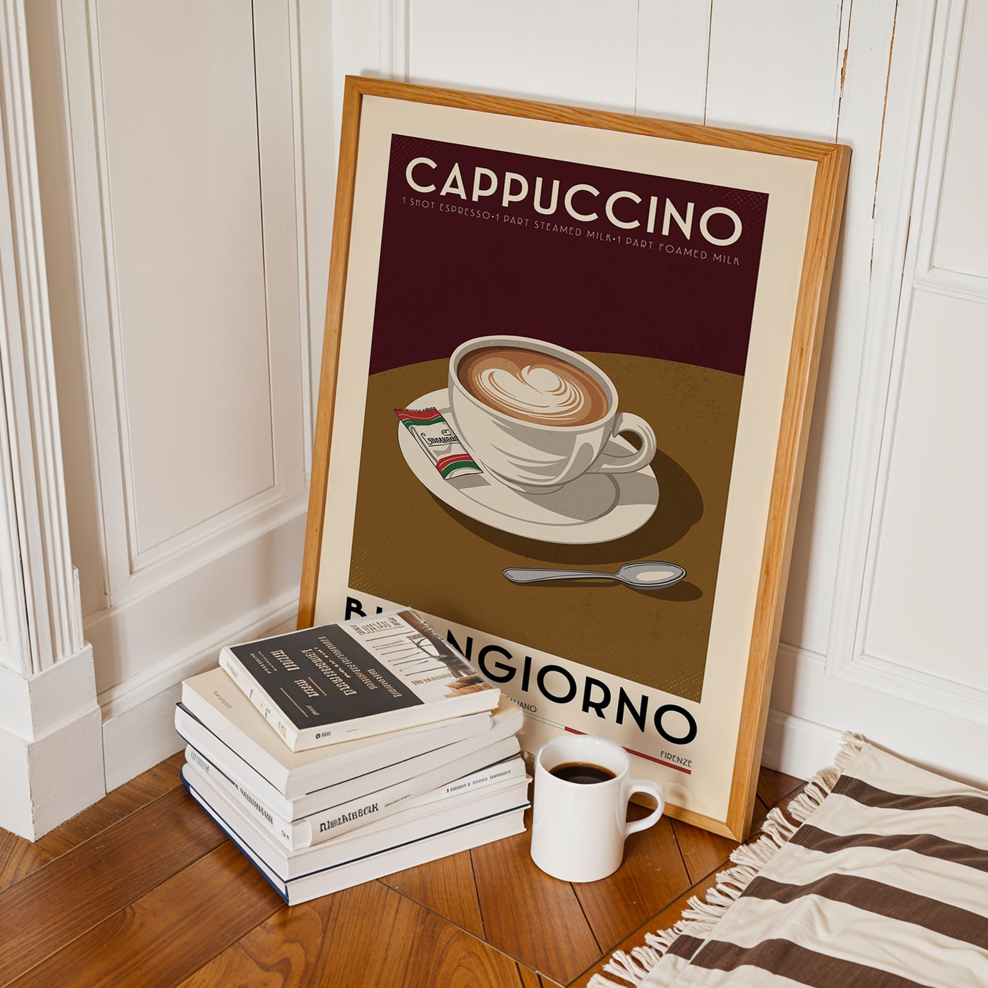 A framed poster of a cup of cappuccino is leaning against a white wall, with a stack of books and a mug of coffee placed next to it on a wooden floor.