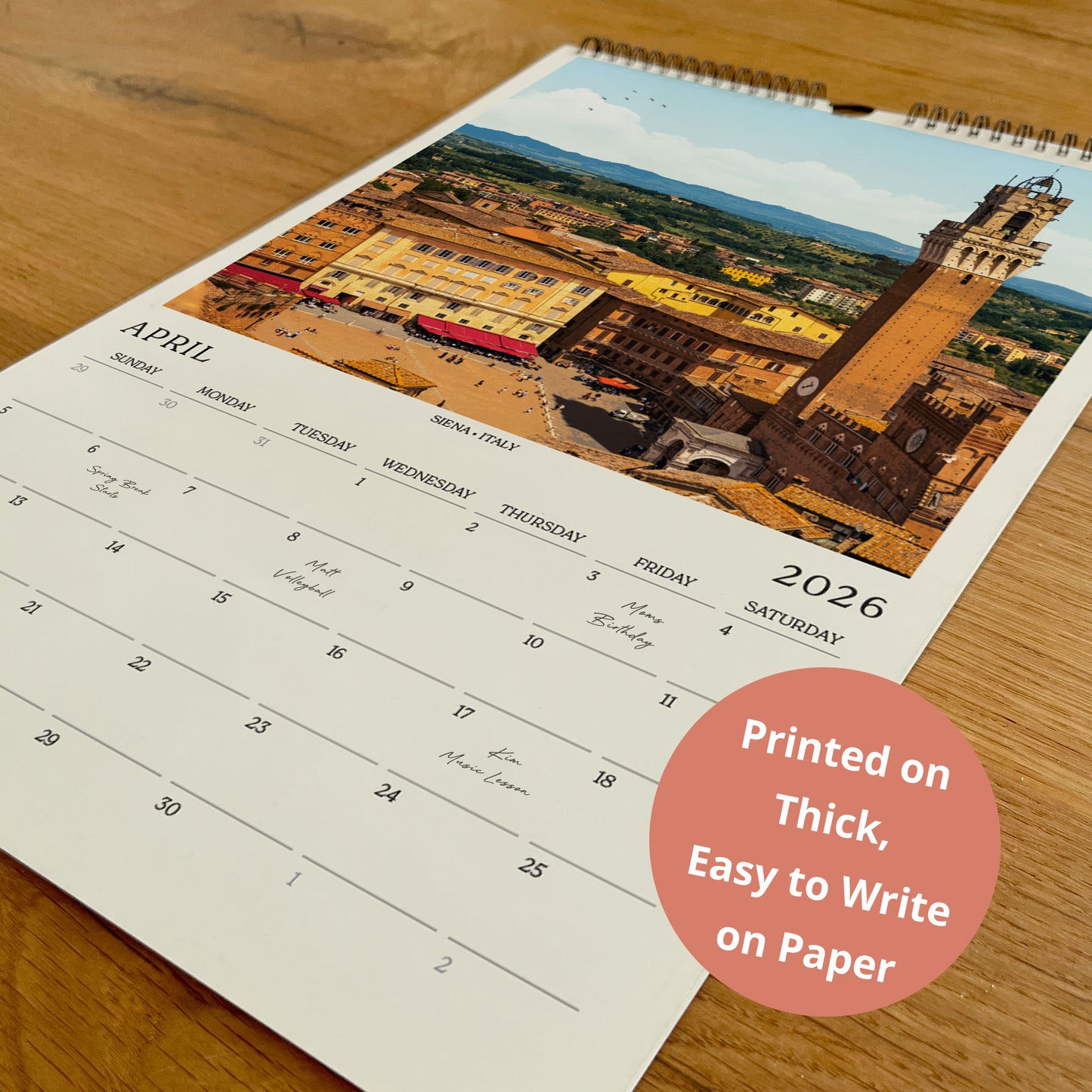 A wall calendar with a printed image of a cityscape on the cover, displaying the days of the week and dates for the month of April.