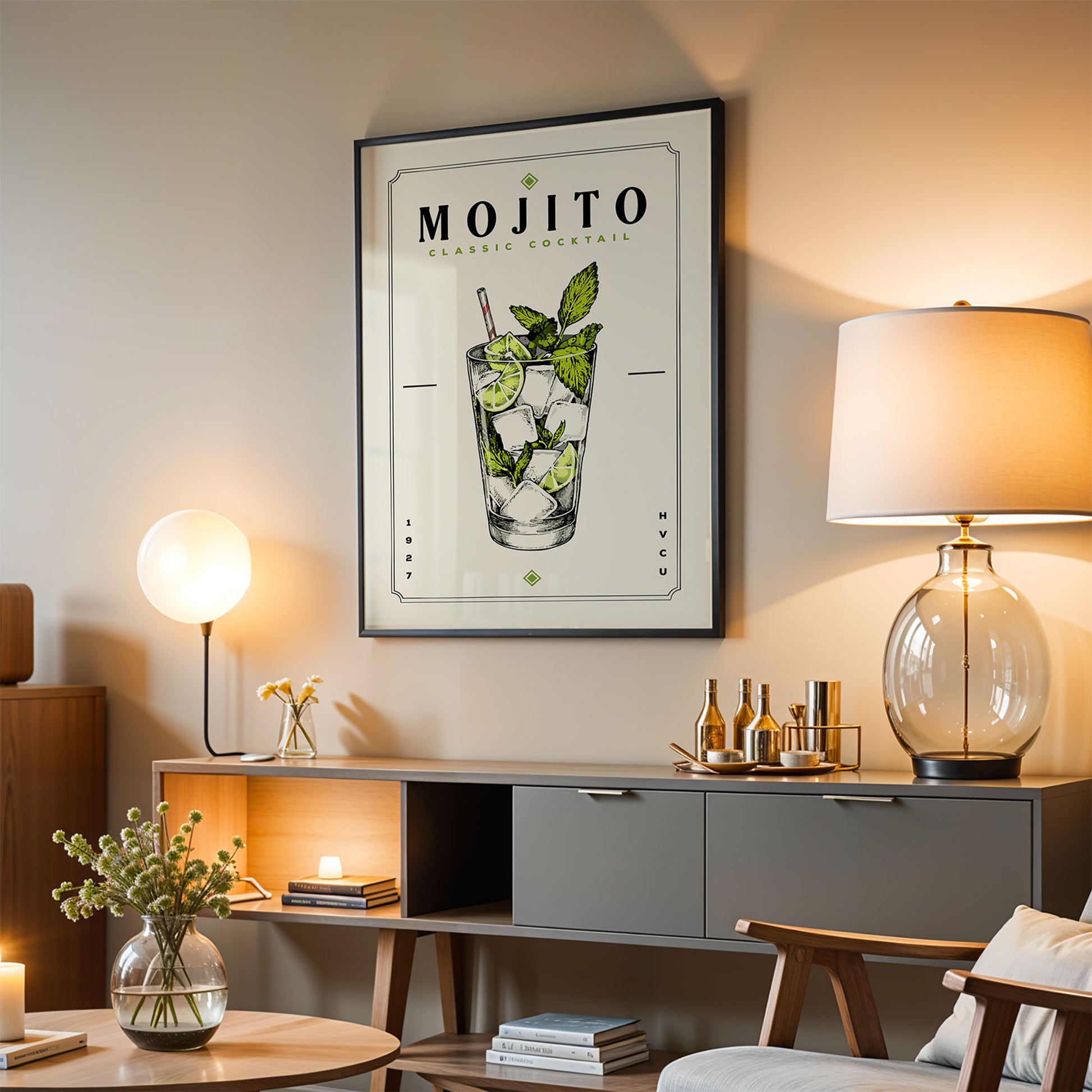 a living room with a framed poster of a mojito cocktail hanging on the wall, a wooden cabinet, a lamp, and a vase with flowers.