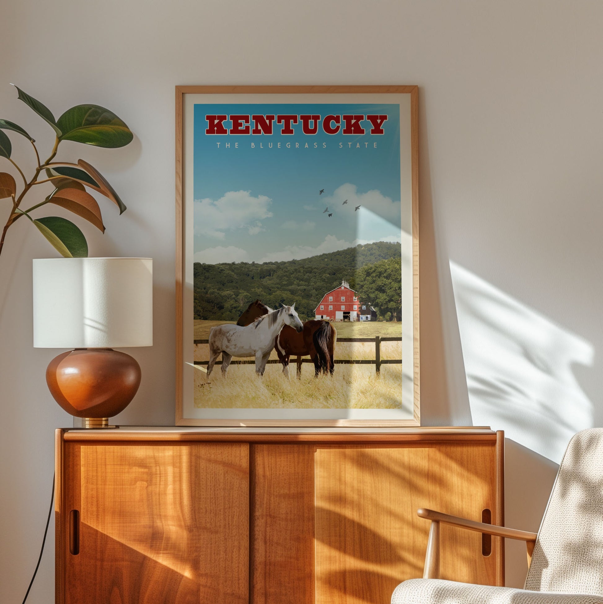 A framed poster of a horse and a barn in Kentucky, with the text "KENTUCKY THE BLUEgrass STATE" prominently displayed.