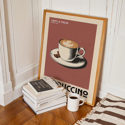 a framed poster of a cup of coffee with the text "CAFFE D'ITALIA" and "MILE 1657" on it, along with a stack of books and a mug of coffee on a wooden floor.