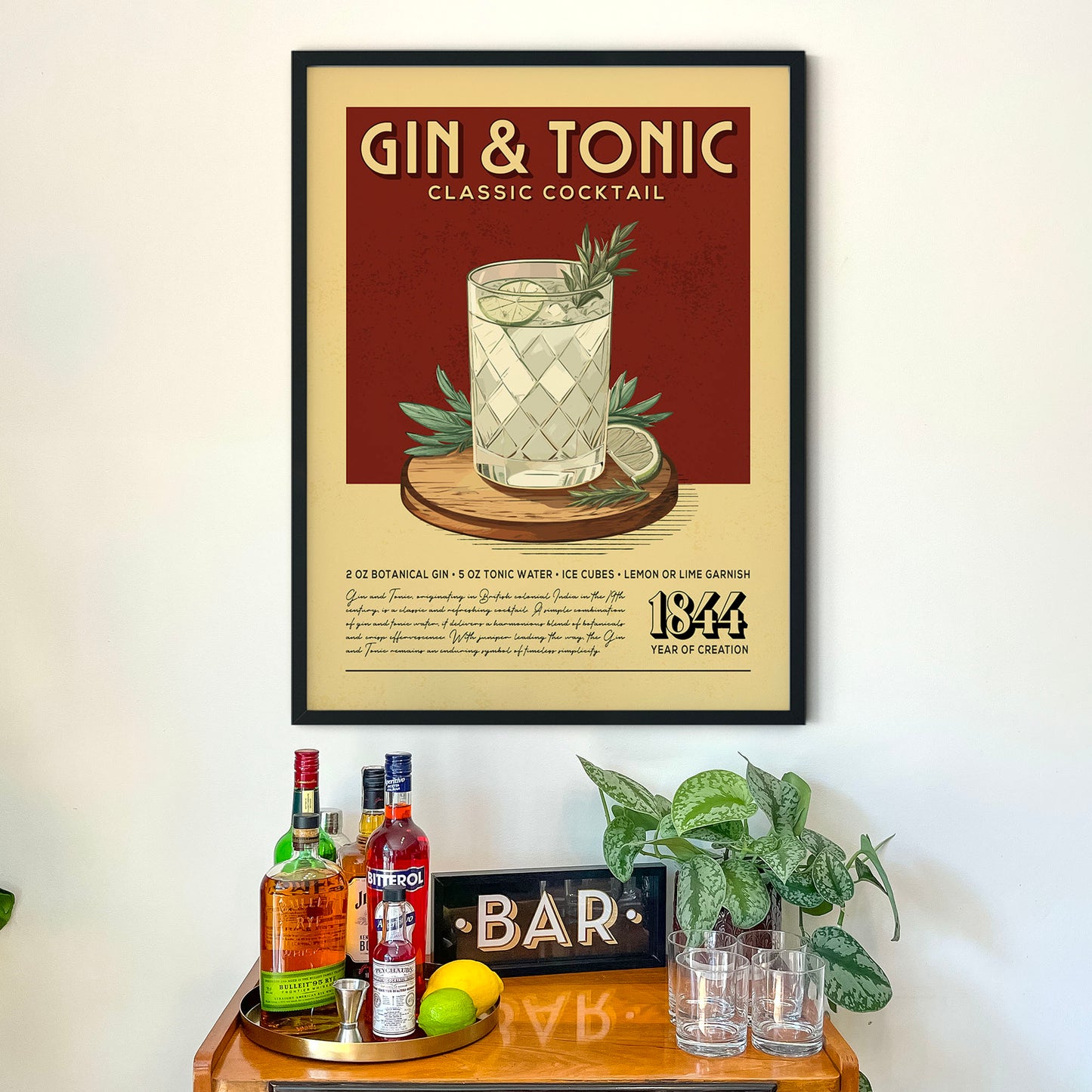 a framed poster of a gin and tonic cocktail on a wall above a wooden bar counter with various liquor bottles and glasses.