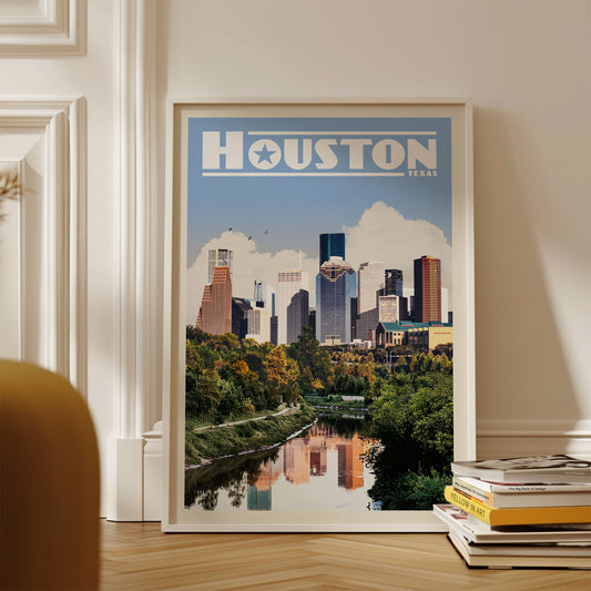 A framed poster of the Houston skyline, with the city's iconic skyscrapers and greenery visible, is displayed on a wall.