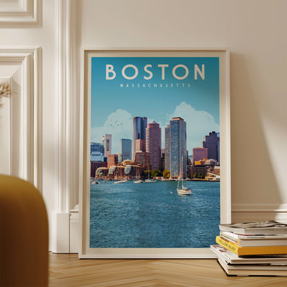 A framed poster of the Boston skyline, with a sailboat in the water, is displayed on a wall.