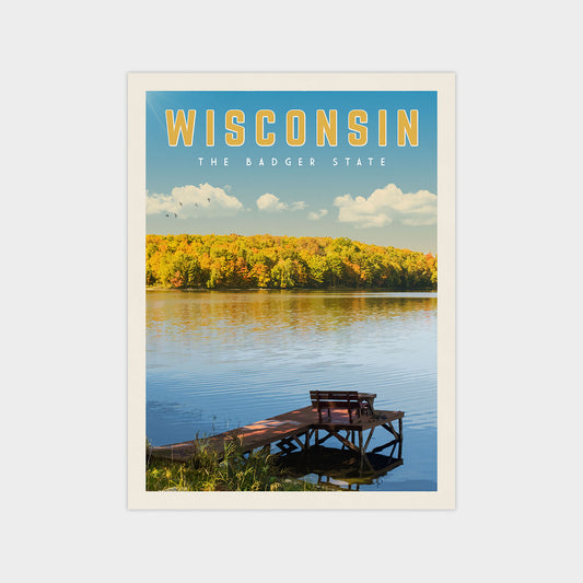 A serene lakeside scene with a wooden dock and benches, surrounded by a forested area with autumn foliage. The text "WISCONSIN" is prominently displayed above the image.