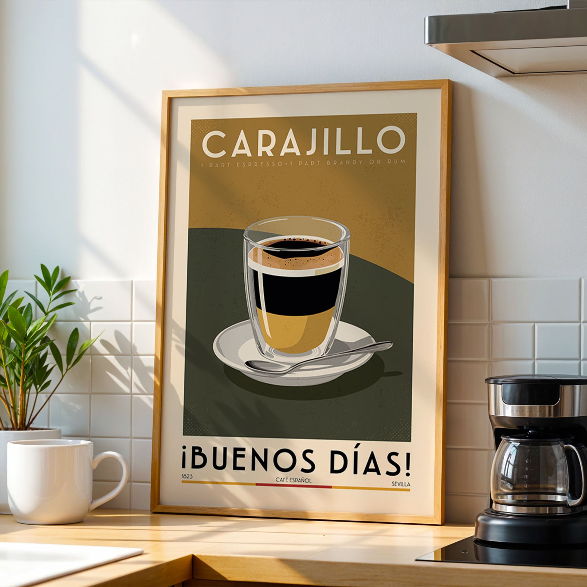 a framed poster of a cup of coffee with the text "CARAJILLO 1 PART ESPRESSO PART BRANDO DE QUE M" (Coffee 1 Part Espresso Part Brando) and "¡BUENOS DÍAS!" (Good Morning Coffee) on it, placed on a kitchen counter.
