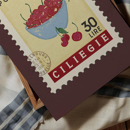 A close-up of a postage stamp featuring a bowl of cherries, with the text &quot;CILIEGIE&quot; and &quot;30 LIRRE&quot; printed on it.
