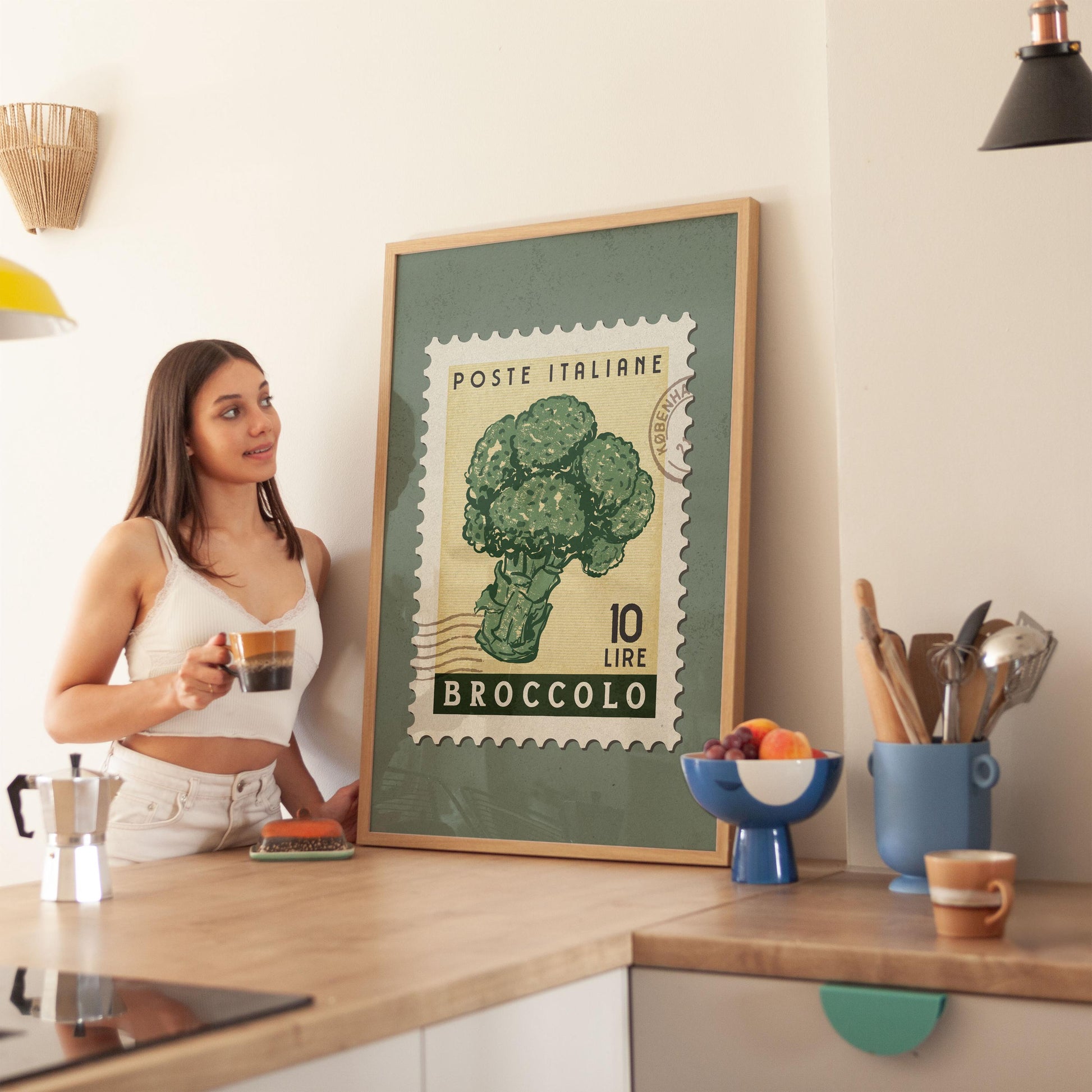 a woman standing in a kitchen next to a poster