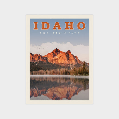 The image is a poster or artwork depicting a scenic landscape with mountains reflected in a lake, surrounded by trees and a clear blue sky.
