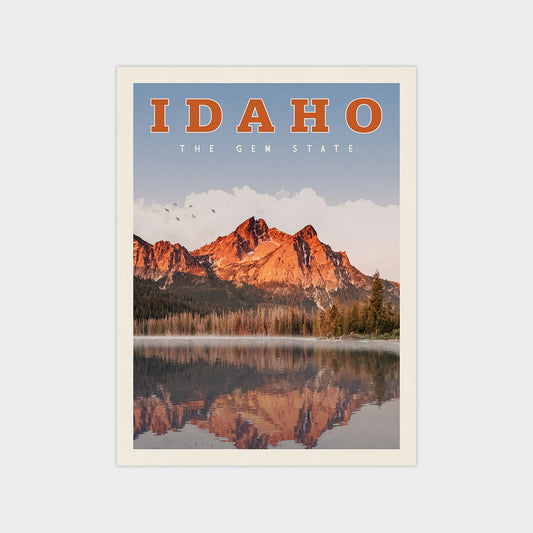 The image is a poster or artwork depicting a scenic landscape with mountains reflected in a lake, surrounded by trees and a clear blue sky.