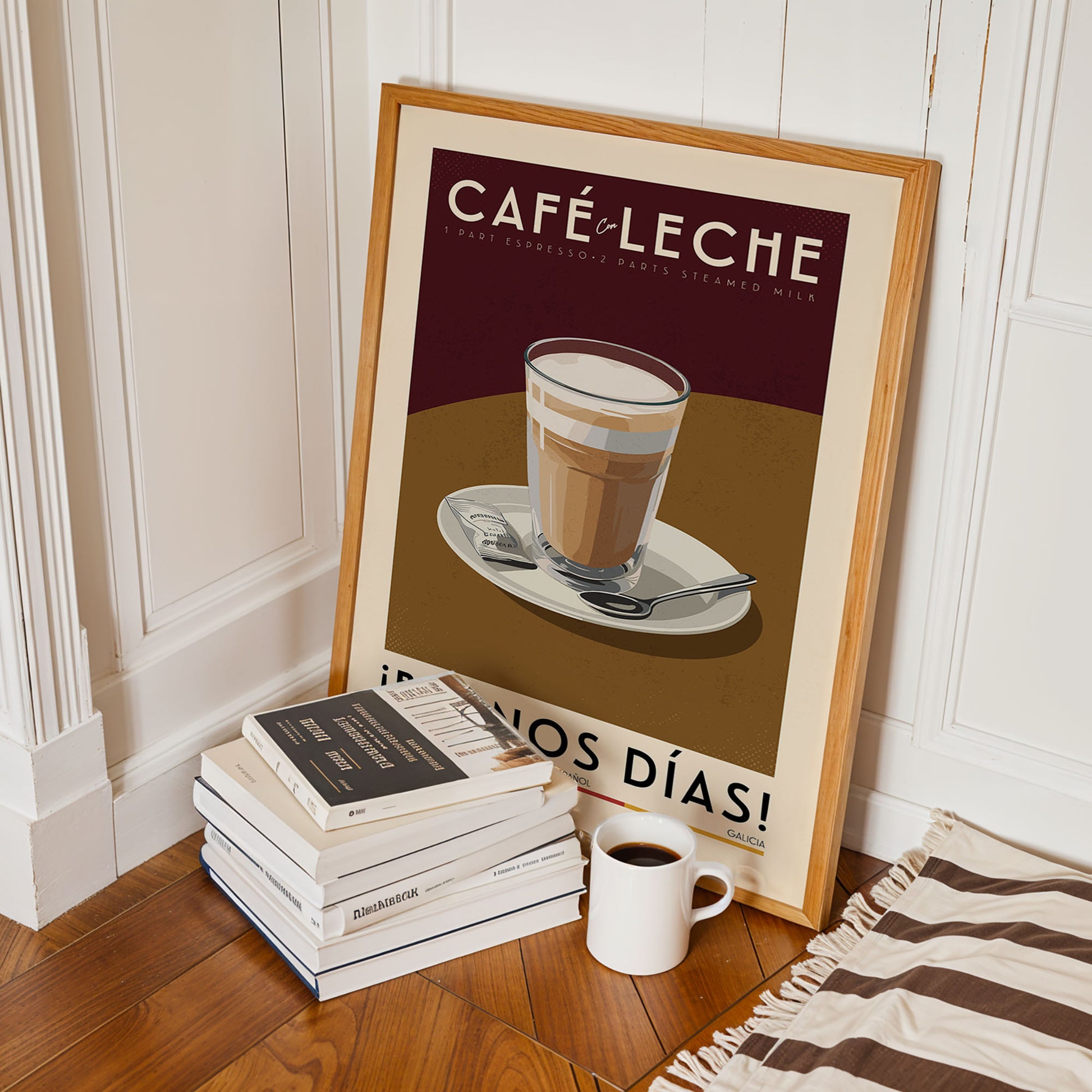 A framed poster of a latte on a plate, surrounded by a stack of books and a cup of coffee, is displayed on a wooden floor.